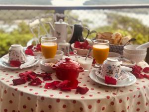 a table with a table cloth with breakfast foods and orange juice at Minas Em Marambaia in Rio de Janeiro