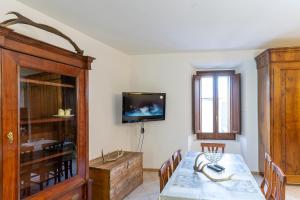 a dining room with a table and a tv on the wall at Emidio e Carmen in Pescocostanzo
