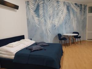 a bedroom with a bed and a table and chairs at Apartament Niebieski Lwowska 56 in Nowy Sącz