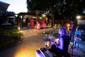 une femme jouant des tambours devant une foule de gens dans l'établissement Camping du Lac de Grolejac, à Groléjac 52 autres photos
