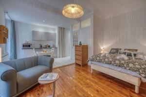 a bedroom with a bed and a couch and a kitchen at Roi Humbert II - Centre-Ville - Caserne de Bonne in Grenoble
