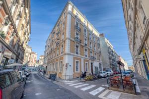 a tall building on a city street with parked cars at Roi Humbert II - Centre-Ville - Caserne de Bonne in Grenoble