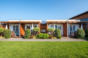 a house with a lawn in front of it at Sunrise-Sarbinowo domki i apartamenty in Sarbinowo +70 photos