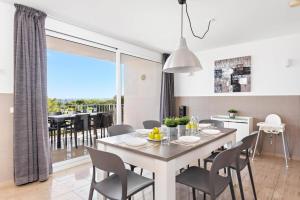 Una cocina y un comedor con mesa y sillas. en Villa Grace by Villa Plus, en Es Mercadal