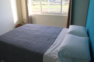 a bed in a bedroom with a window at Cómoda y Acogedora Casa cerca de Av Torreón Nuevo in Morelia