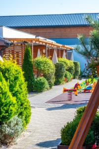 a garden with a building and a playground at Sunrise-Sarbinowo domki i apartamenty in Sarbinowo