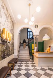 a lobby with a staircase and a dog in the distance at JOY Plaza de Armas in Seville +58 photos
