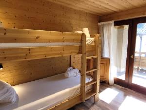a bedroom with two bunk beds in a log cabin at Appartement rénové aux Gets avec parking et vue sur pistes, jusqu'à 8 pers. - FR-1-598-124 in Les Gets