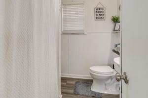 a white bathroom with a toilet and a window at Nature Lovers Haven with Fire Pit in Pangburn! in Pangburn +16 photos
