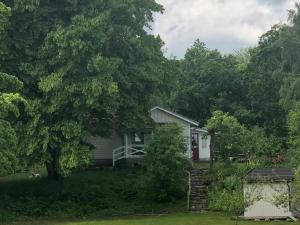 a house in the middle of a yard with trees at Solröje in Simrishamn