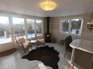 a living room with a table and chairs and windows at Solröje in Simrishamn