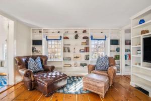 a living room with two chairs and a television at Large waterfront home with direct beach access in Dennis +43 photos