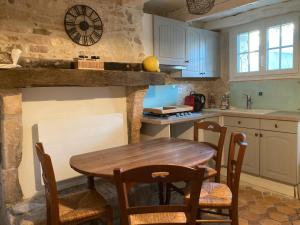 a kitchen with a wooden table and chairs at La Bourriche in Dolus-d'Oléron