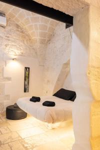 a bed in a room with a stone wall at Rifugio Del Monsignore in Ostuni