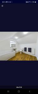 una imagen de una sala de estar con una habitación blanca en The White Bungalow, en Boughton