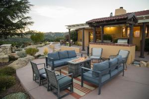 eine Terrasse mit Stühlen und einer Feuerstelle vor einem Haus in der Unterkunft Kiler Ranch House & Apartment in Paso Robles