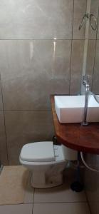 a bathroom with a white toilet and a sink at Chalé Taipu in Marau