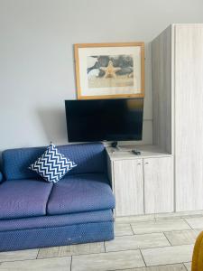 un salon avec un canapé bleu et une télévision dans l'établissement Shaka Shores 2B, à Durban