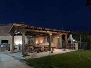 a wooden pergola with a picnic table in a yard at Casas Rurales LA HUERTA DEL CURATO I in Tolbaños