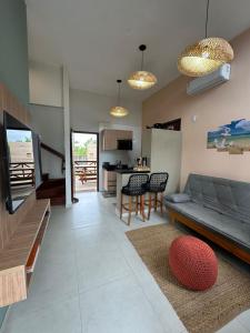 a living room with a couch and a kitchen at Chalé Dunas Atins - Chalé de temporada em Atins in Barreirinhas