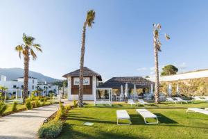a resort with palm trees and lounge chairs in a yard at Luxury penthouse with ocean views in Estepona