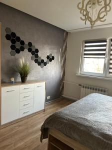 sypialnia z łóżkiem, komodą i oknem w obiekcie Apartament Wieluńska w Warszawie +28 zdjęć