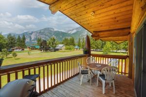 une terrasse en bois avec une table et des chaises dessus dans l'établissement Bella Coola Grizzly Tours and Resort, à Hagensborg