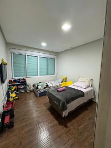 a bedroom with two beds and a tv in it at Casa alto padrão piscina aquecida in Joinville