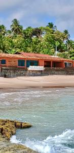 a train sitting on the beach next to the ocean at Ô de Casa in Japaratinga