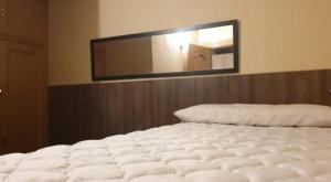 a white bed in a room with a mirror at SIERRA NEVADA Acogedor 2 habitaciones y bien ubicado Edifico Europa in Sierra Nevada