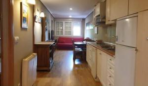 a kitchen with a red couch in a room at SIERRA NEVADA Acogedor 2 habitaciones y bien ubicado Edifico Europa in Sierra Nevada