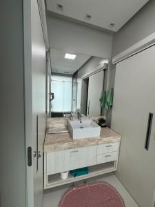 a bathroom with a sink and a large mirror at Casa alto padrão piscina aquecida in Joinville