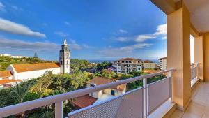 balcone con vista su una torre dell'orologio. di Caniço Zentrum Wohnung a Caniço