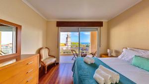 una camera con letto e vista su un edificio di Caniço Zentrum Wohnung a Caniço