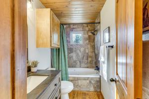 a bathroom with a tub and a toilet and a sink at Hot Tub and Fireplace Cozy Angel Fire A-Frame Cabin in Angel Fire +19 photos