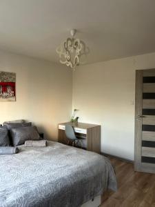 sypialnia z łóżkiem obok biurka i łóżkiem o wymiarach 60 cm w obiekcie Apartament Wieluńska w Warszawie