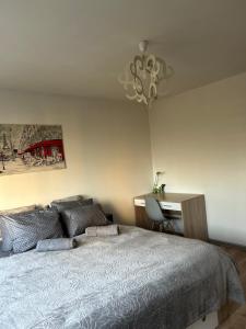 sypialnia z łóżkiem, biurkiem i żyrandolem w obiekcie Apartament Wieluńska w Warszawie