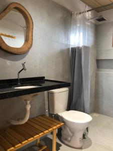 un bagno con un water, un lavandino e uno specchio di Casa Vento Parte Baixa a Luis Correia