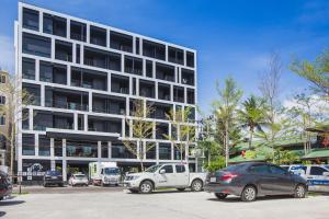 a parking lot with cars parked in front of a building at Blu Monkey Hub and Hotel Phuket Town- Free All Day Coworking space in Phuket Town