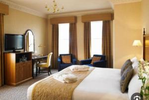 une chambre d'hôtel avec un lit, un bureau et une télévision dans l'établissement Number 10, à Blackpool