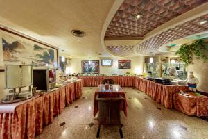 un restaurante con mesas con cortinas rojas en una habitación en Chungli Business Hotel en Zhongli