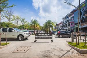 a sign in the middle of a parking lot with cars at Blu Monkey Hub and Hotel Phuket Town- Free All Day Coworking space in Phuket Town