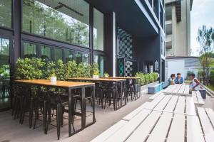 a restaurant with tables and chairs outside of a building at Blu Monkey Hub and Hotel Phuket Town- Free All Day Coworking space in Phuket Town