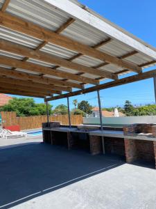 a wooden pergola on top of a patio at Comfort Home Guest House in East London