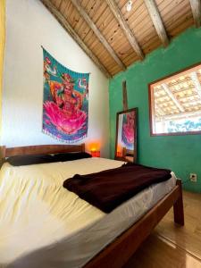 a bedroom with a bed with a painting on the wall at Sunset Lagoon Praia do Rosa in Praia do Rosa +99 photos