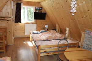 a bedroom with a bed in a wooden cabin at Cottage Tatry Wellness in Tatranska Strba