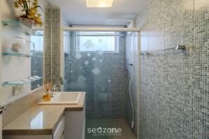 a bathroom with a glass shower and a sink at Apto 3Q quadra mar c/ Garagem em Piçarras NRA0490 in Piçarras +11 photos