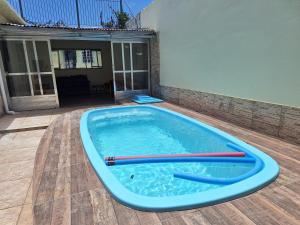 a large swimming pool with two red paddles in it at Aconchego do Amor com Suíte com piscina in Pelotas