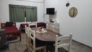 een eetkamer met een tafel, stoelen en een bank bij La Arbolada in Mar del Plata +8 foto's