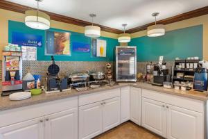 a coffee shop with white cabinets and blue walls at Best Western Harbour Inn & Suites Huntington - Sunset Beach in Huntington Beach